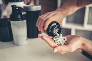 Förbereder testobooster och proteinpulver i köket