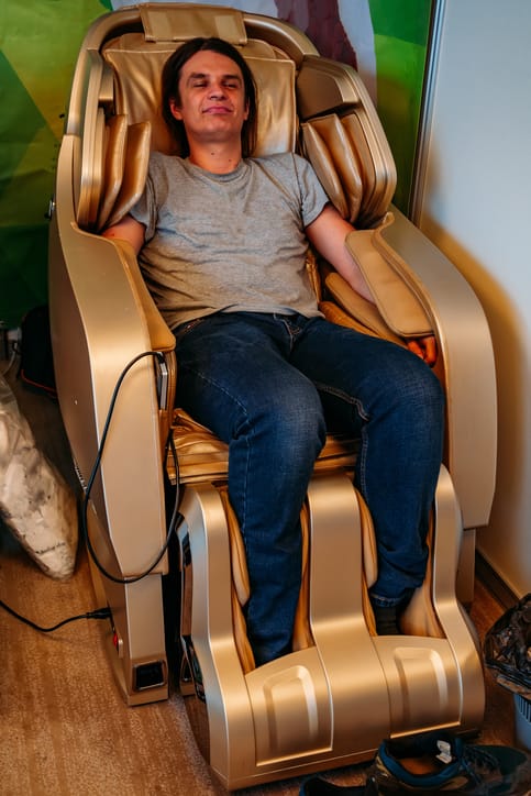 Glad man i massagefåtölj